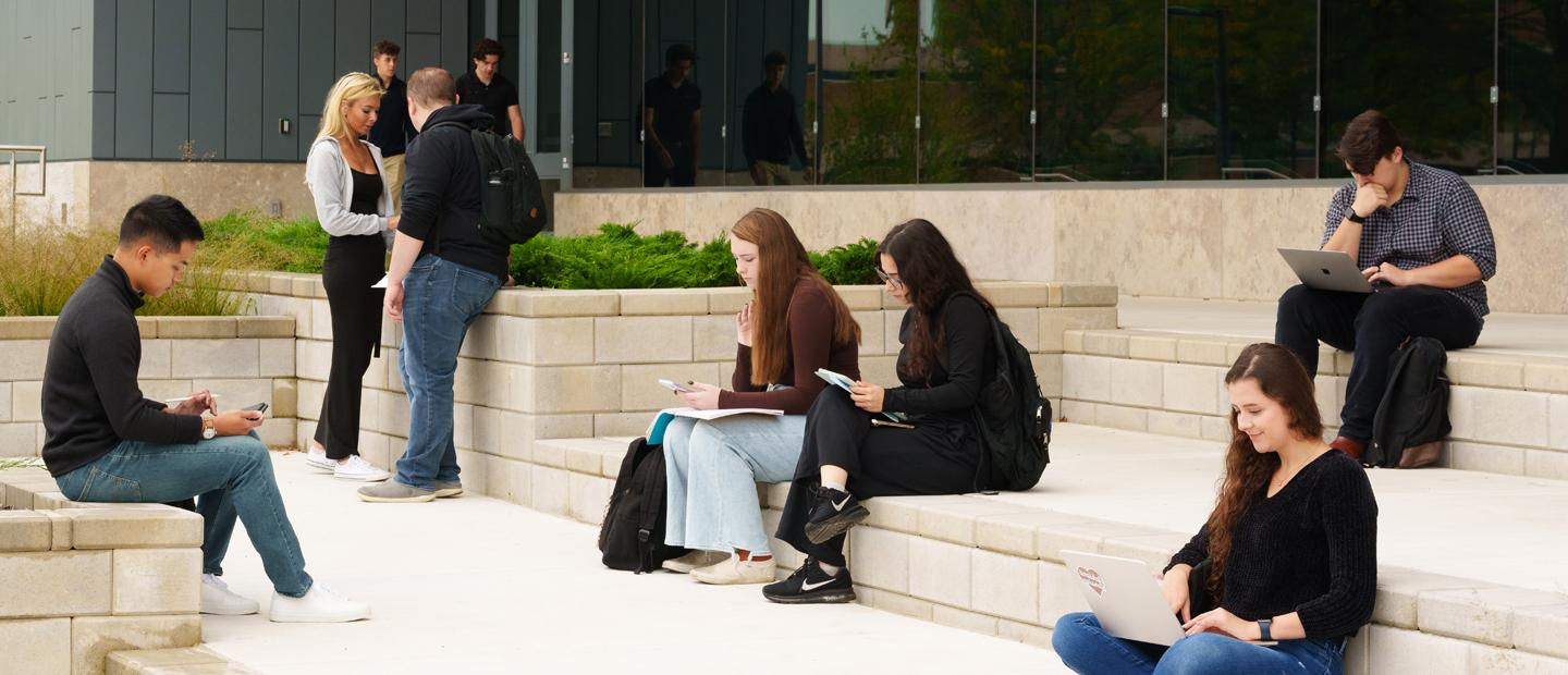 Students scattered around the steps of a building at Oakland University